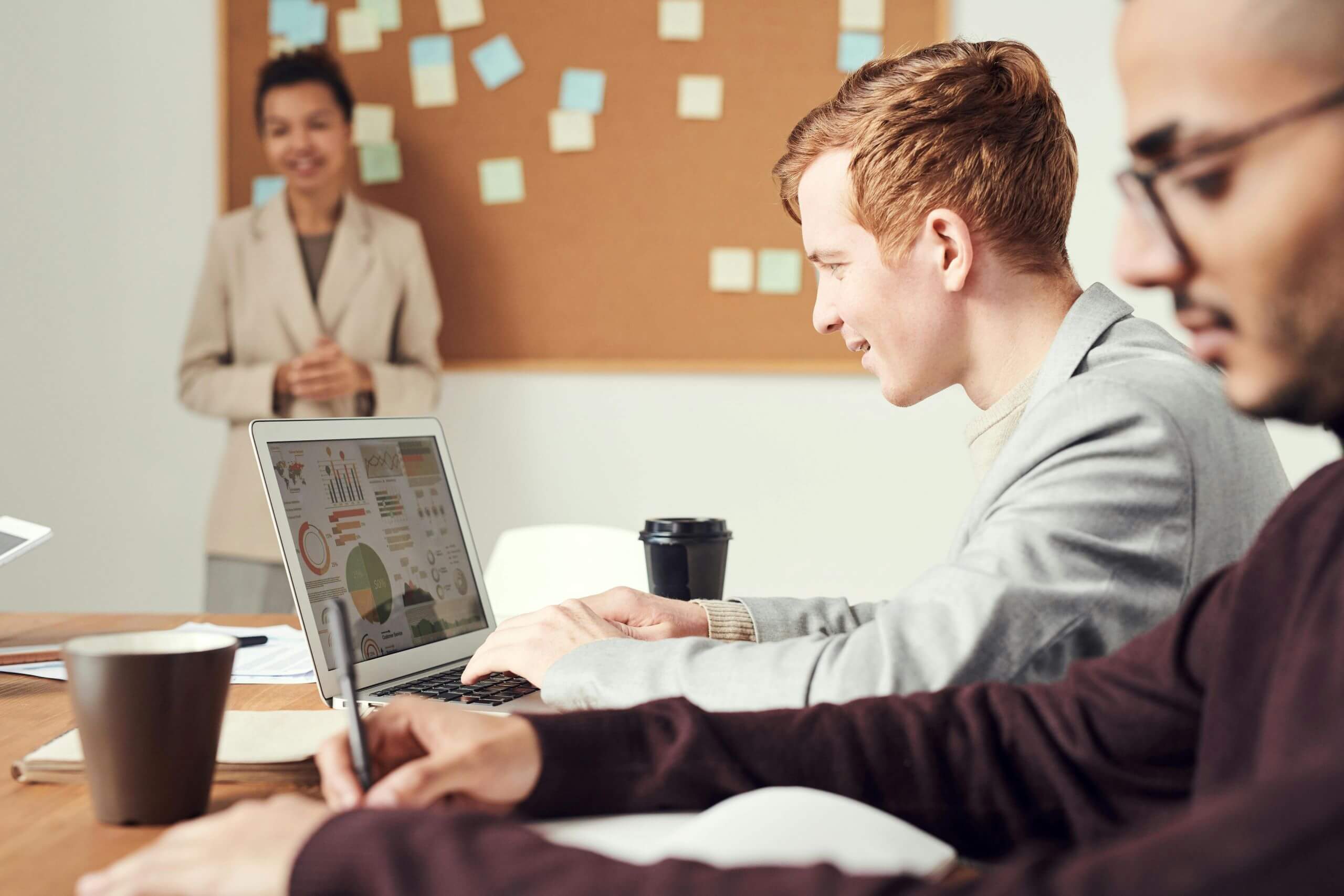 Young workers looking at graphs on laptop